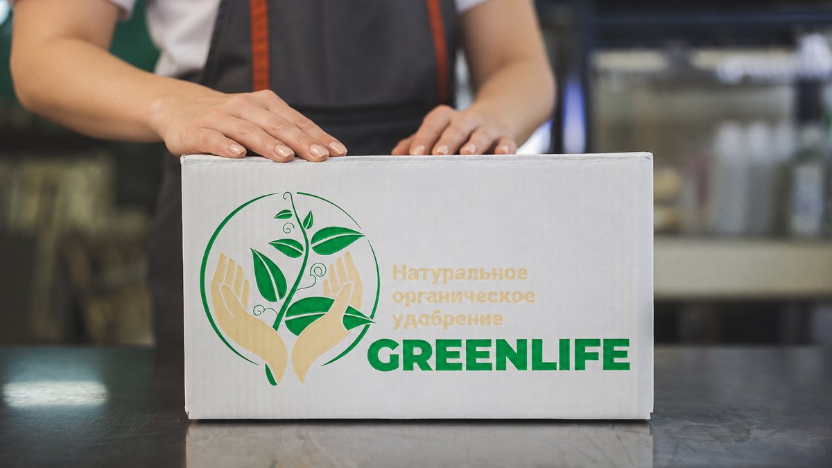 Упаковщик держит фирменную коробку Green Life